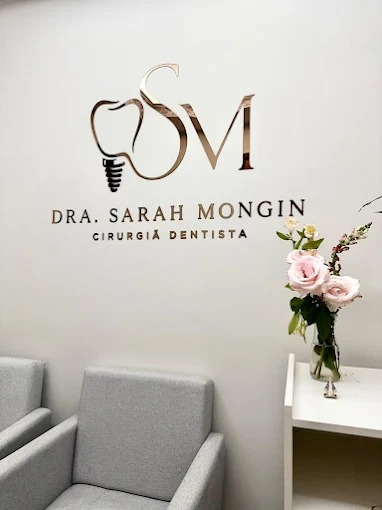 Recepção do consultório com poltronas, flores e a marca Dra. Sarah Mongin na parede