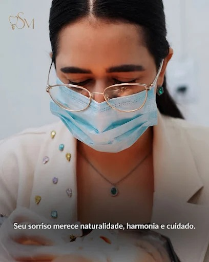 Dra. Sarah durante atendimento odontológico, com equipamentos de proteção